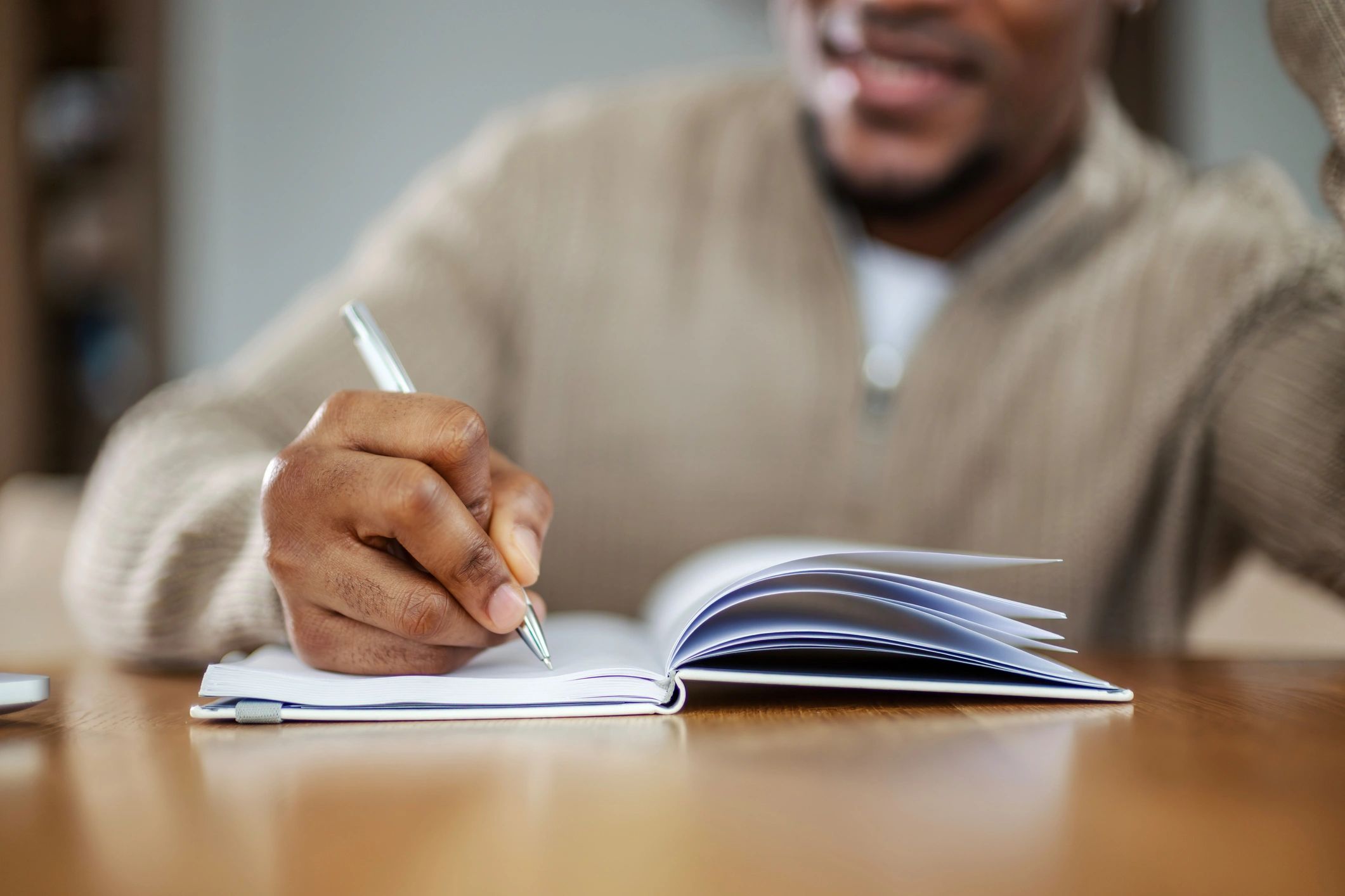 Person writing reflectively in a journal during a coaching process