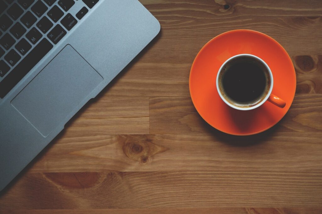 Laptop with a cup of coffee next to it